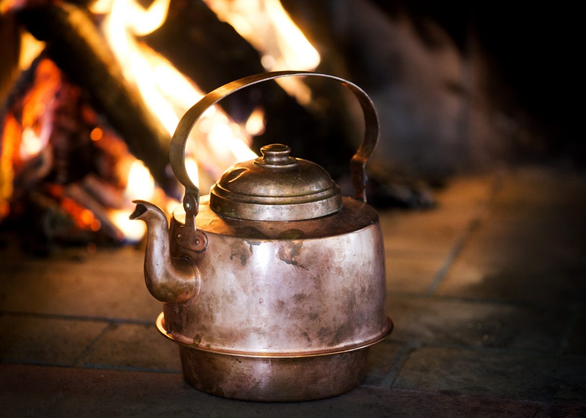 Coffee kettle in copper with a fire in the background